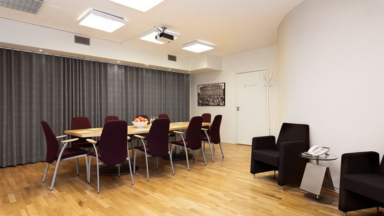 Group room with board seating, wooden floor and white walls