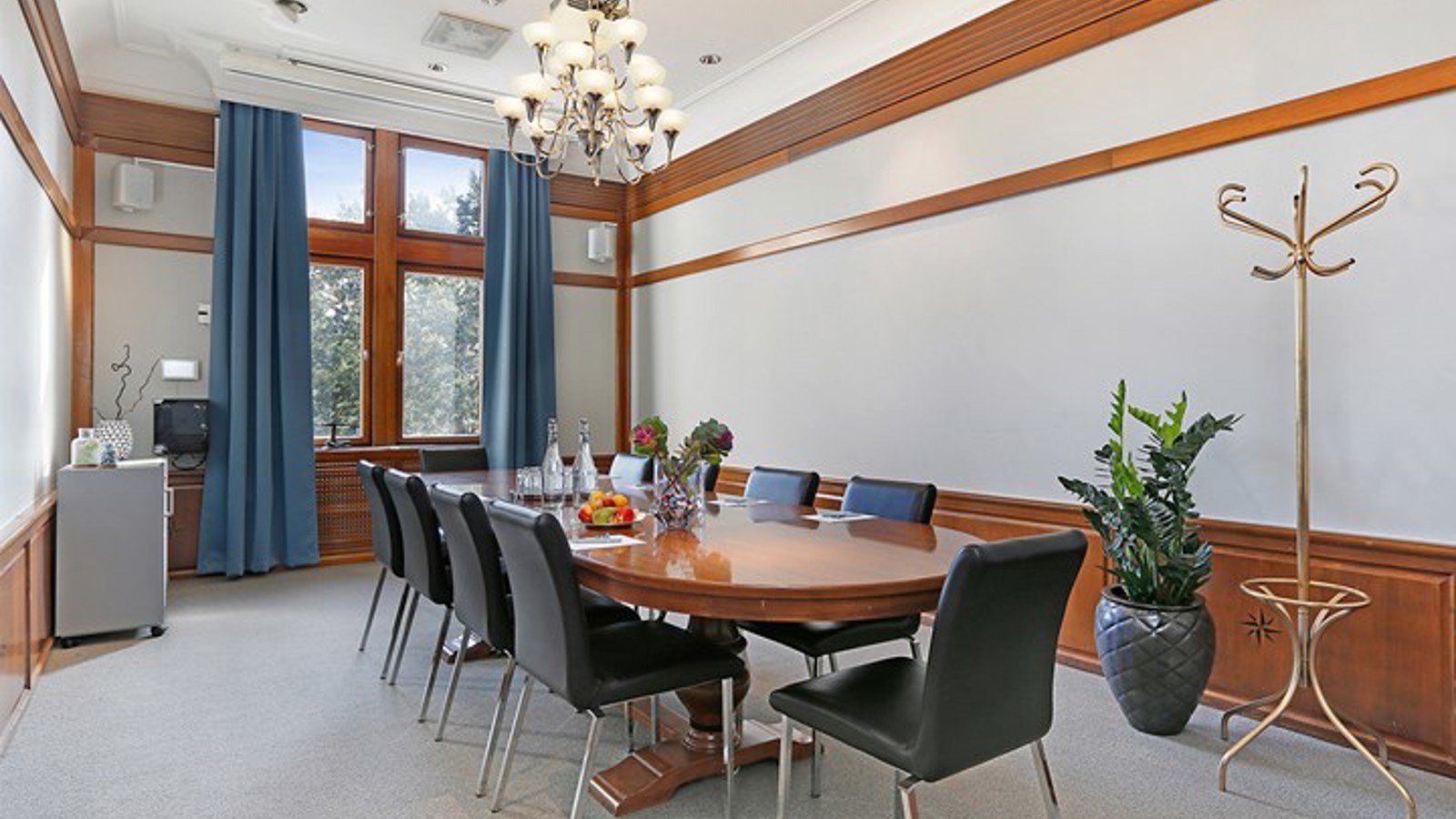 Boardroom with gray walls, blue curtains and wooden details