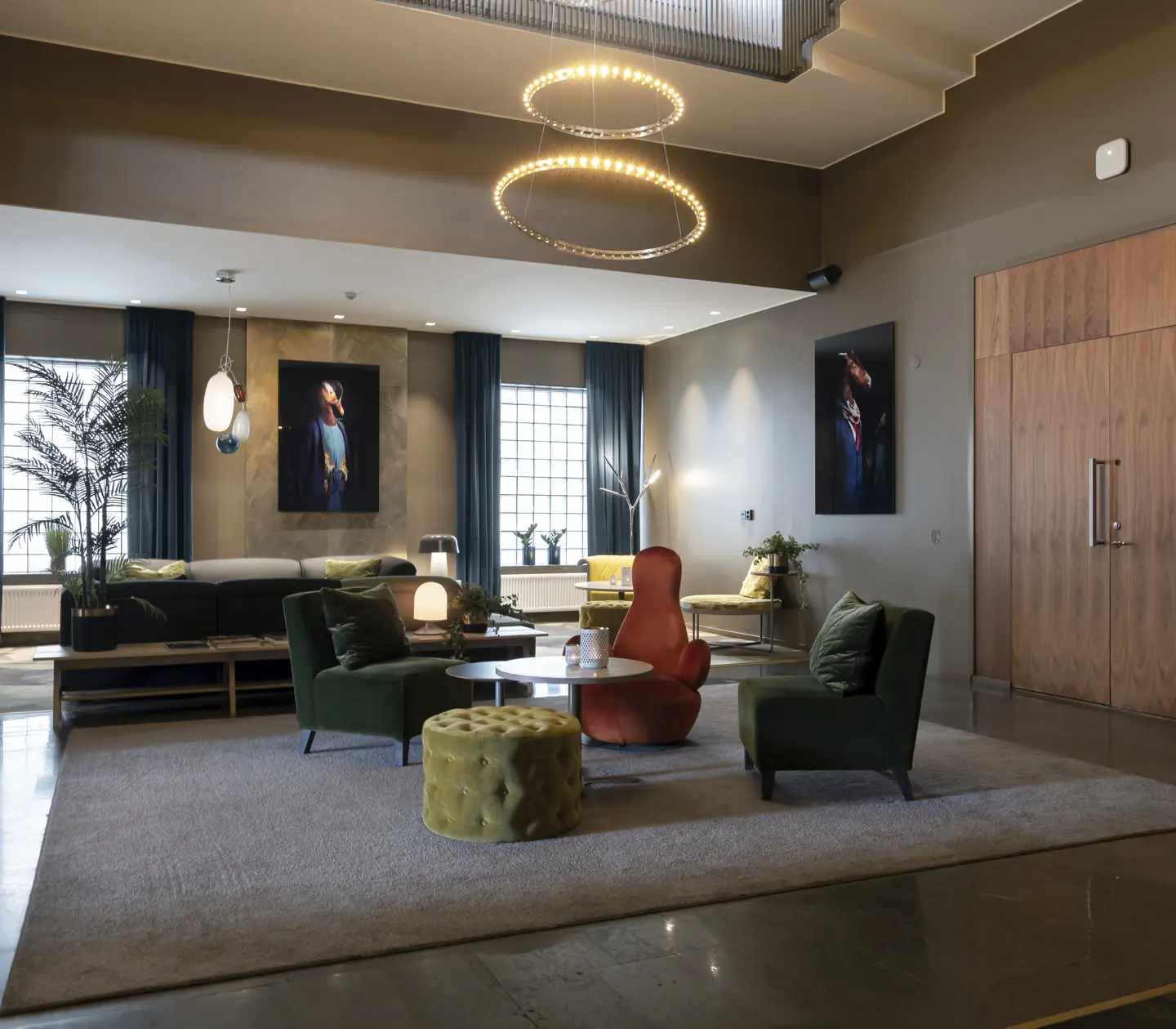 Modern hotel lobby with stylish seating, circular ceiling lights, and contemporary artwork on the walls.