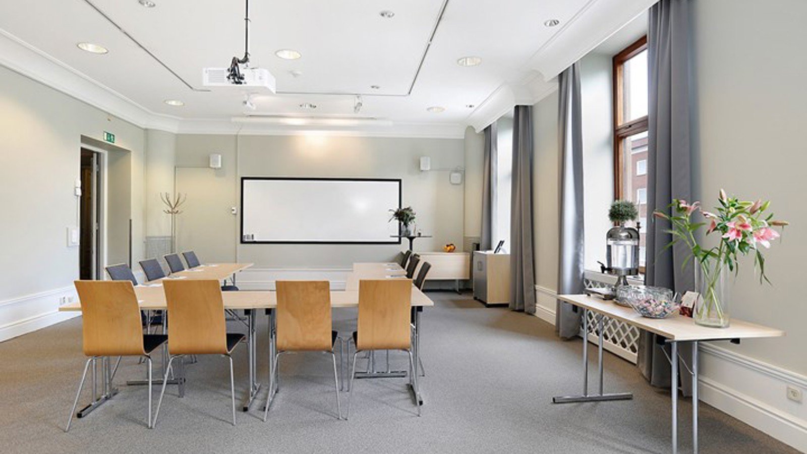 Grey, bright conference room with U-shaped seating