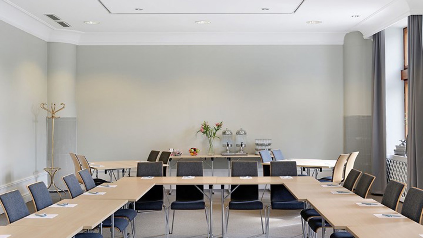 Conference room with u-shaped seating, gray walls and large windows