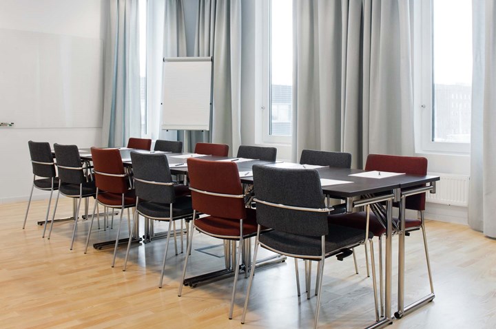 Conference room with board seating, large windows, gray curtains and dark chairs