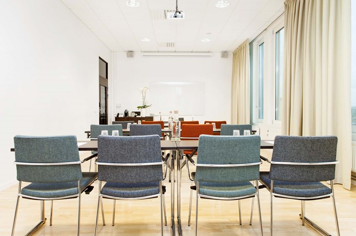 Conference room with lined up gray chairs and white walls