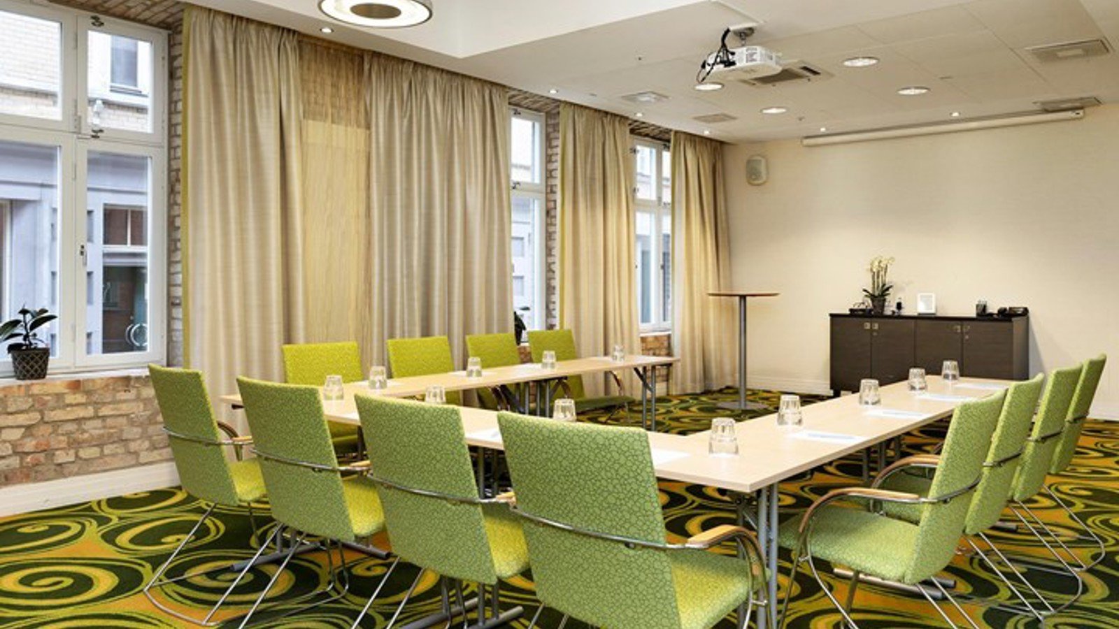 Conference room with green chairs, green patterned carpet and large windows