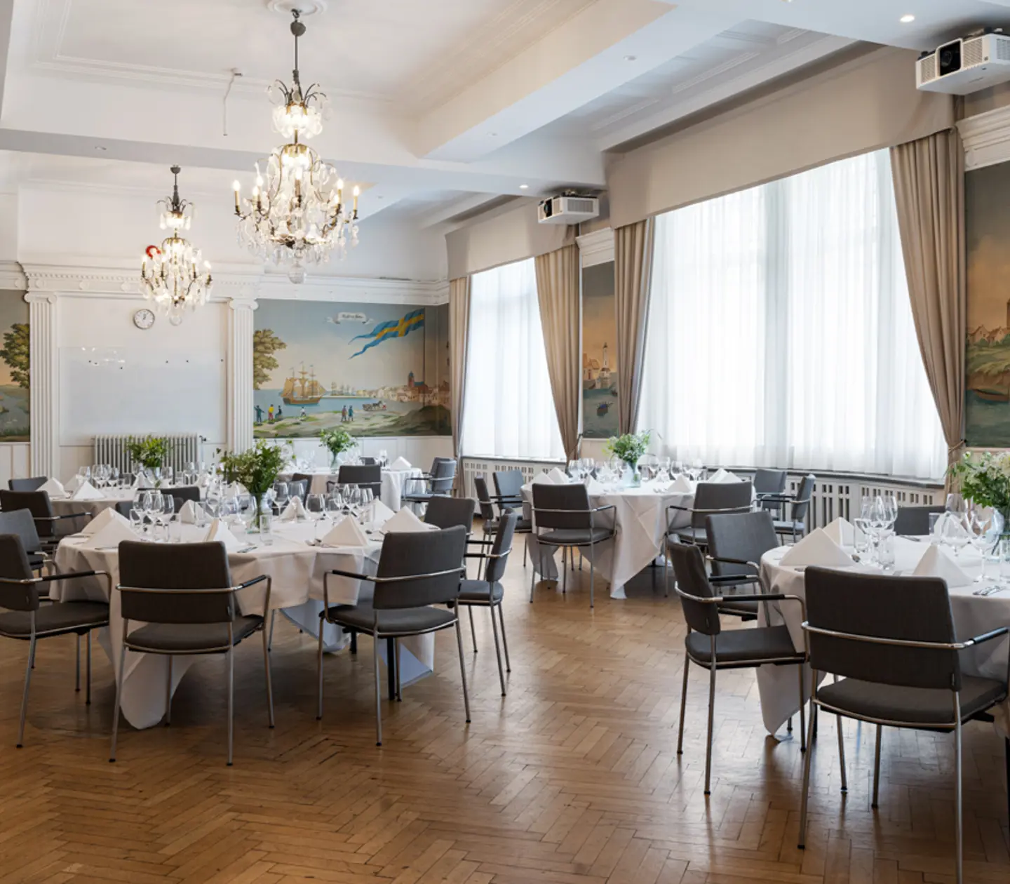 Konferensrum med kristallkronor i taket förberett för möte