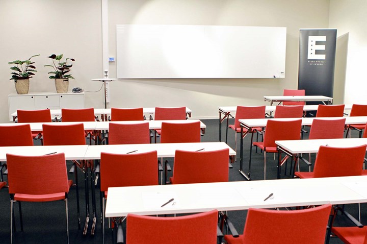 Conference room with school seating, white tables, red chairs