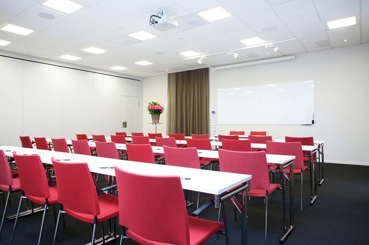 Conference room with white tables, red chairs, black floor