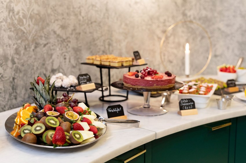A food buffet with fruit and pastries