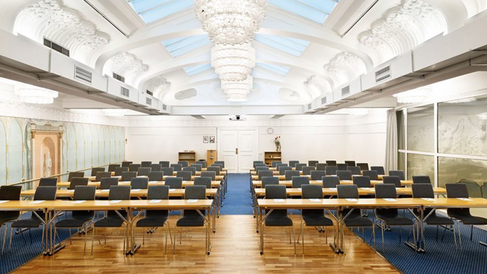 Large conference room with lined up chairs, skylights and white walls