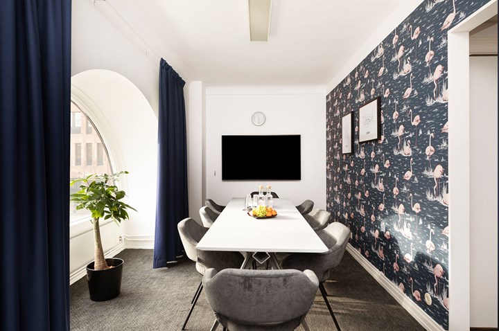 Conference room with board seating, round window and a patterned background wall