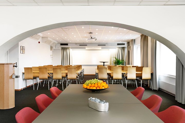 Conference room with lined up chairs, white walls, dark floor and large window