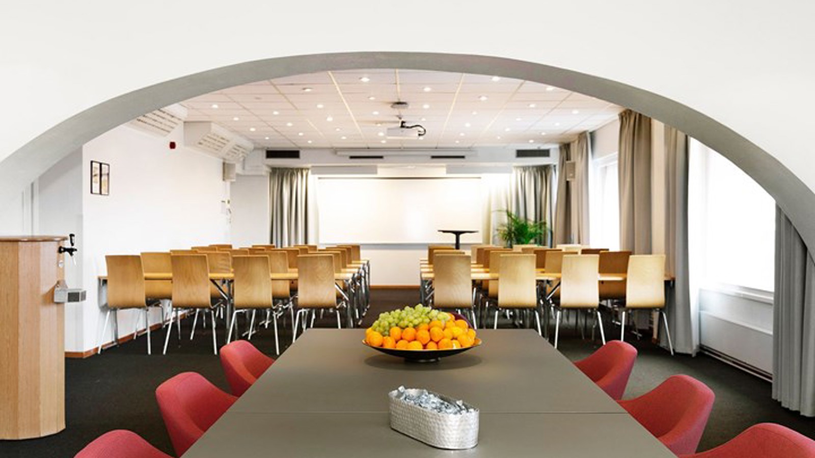 Conference room with lined up chairs, white walls, dark floor and large window