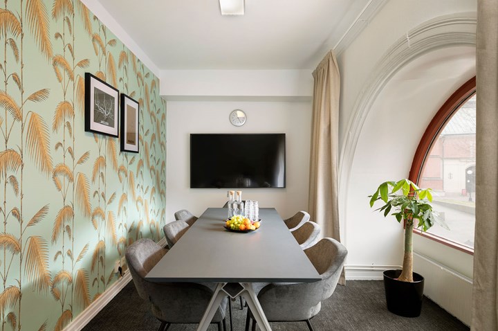 Conference room with board seating, patterned stock wall and large crescent window