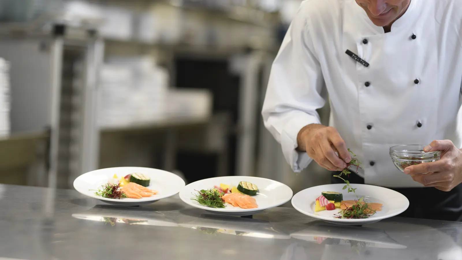 Kock som lägger upp mat på tallrikar