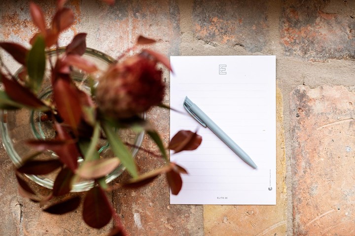 Pad, pen and a beautiful bouquet photographed from above