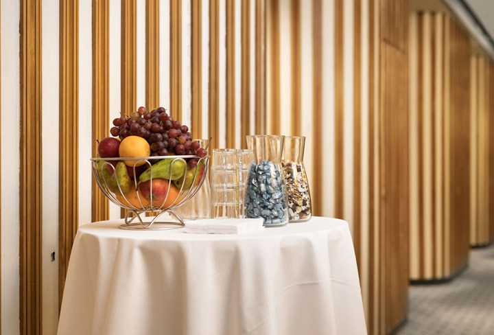 Detaljbild på bord med vit duk, fruktskål, glas och godis