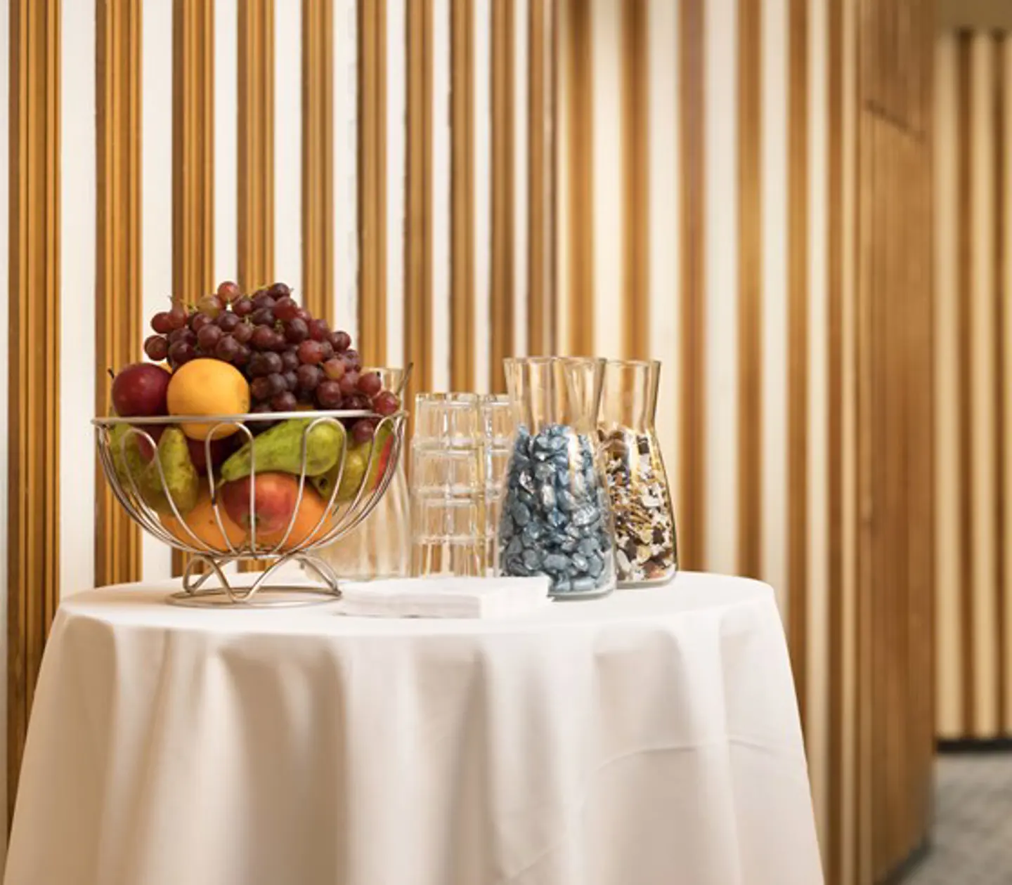 Detaljbild på bord med vit duk, fruktskål, glas och godis