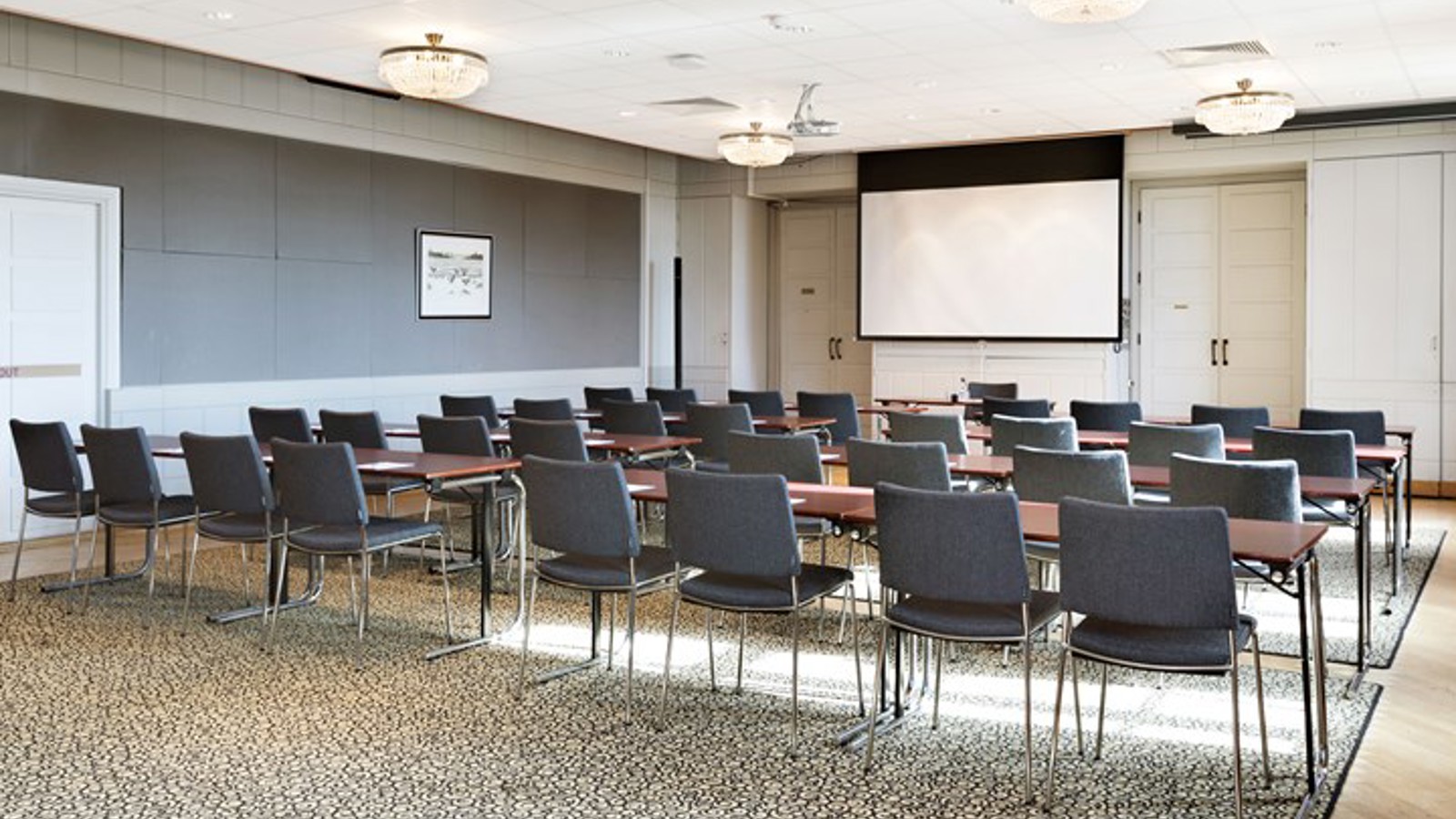 Conference room with cinema seating, a projector, gray carpet and gray chairs