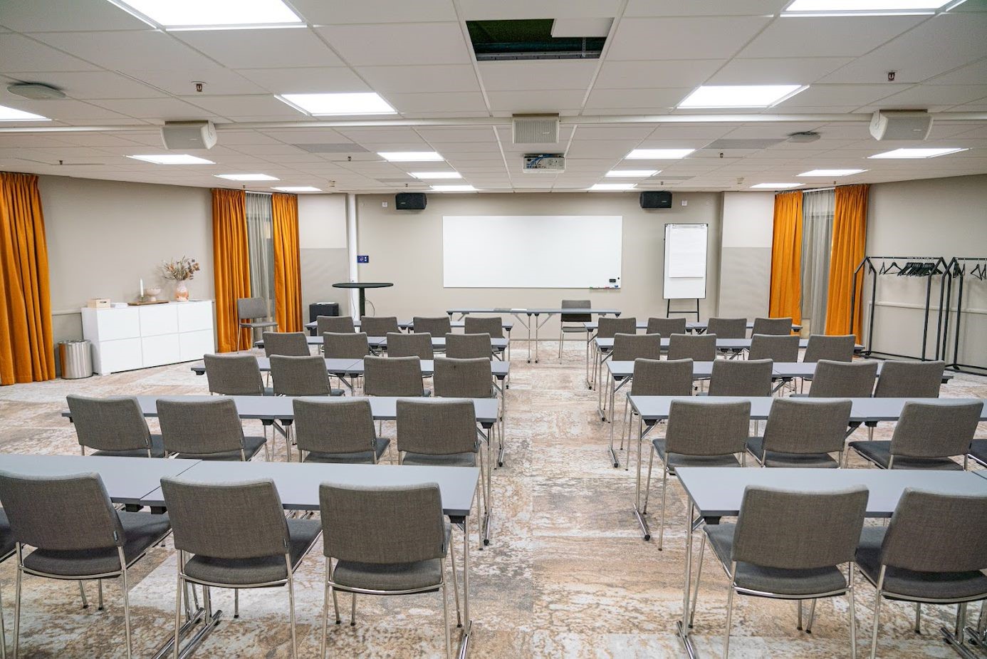 Konferensrum med skolsittning och grå stolar