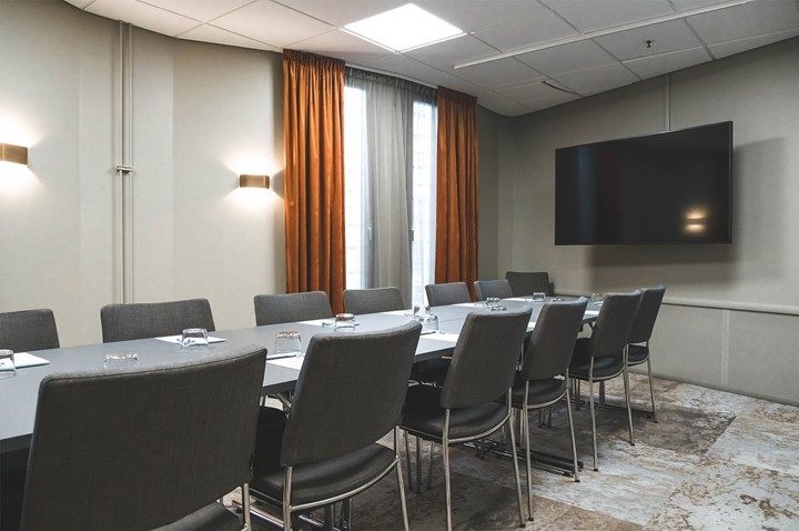 Närbild på block, pennor, glas, grått bord i konferensmiljö