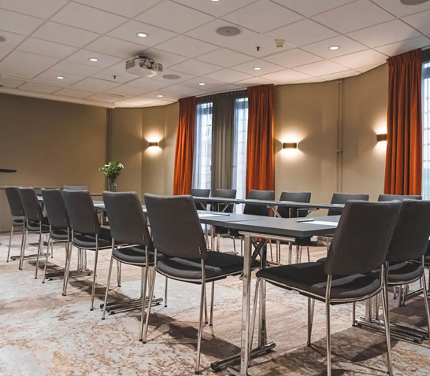 Conference room with u-shaped seating, gray chairs and red curtains