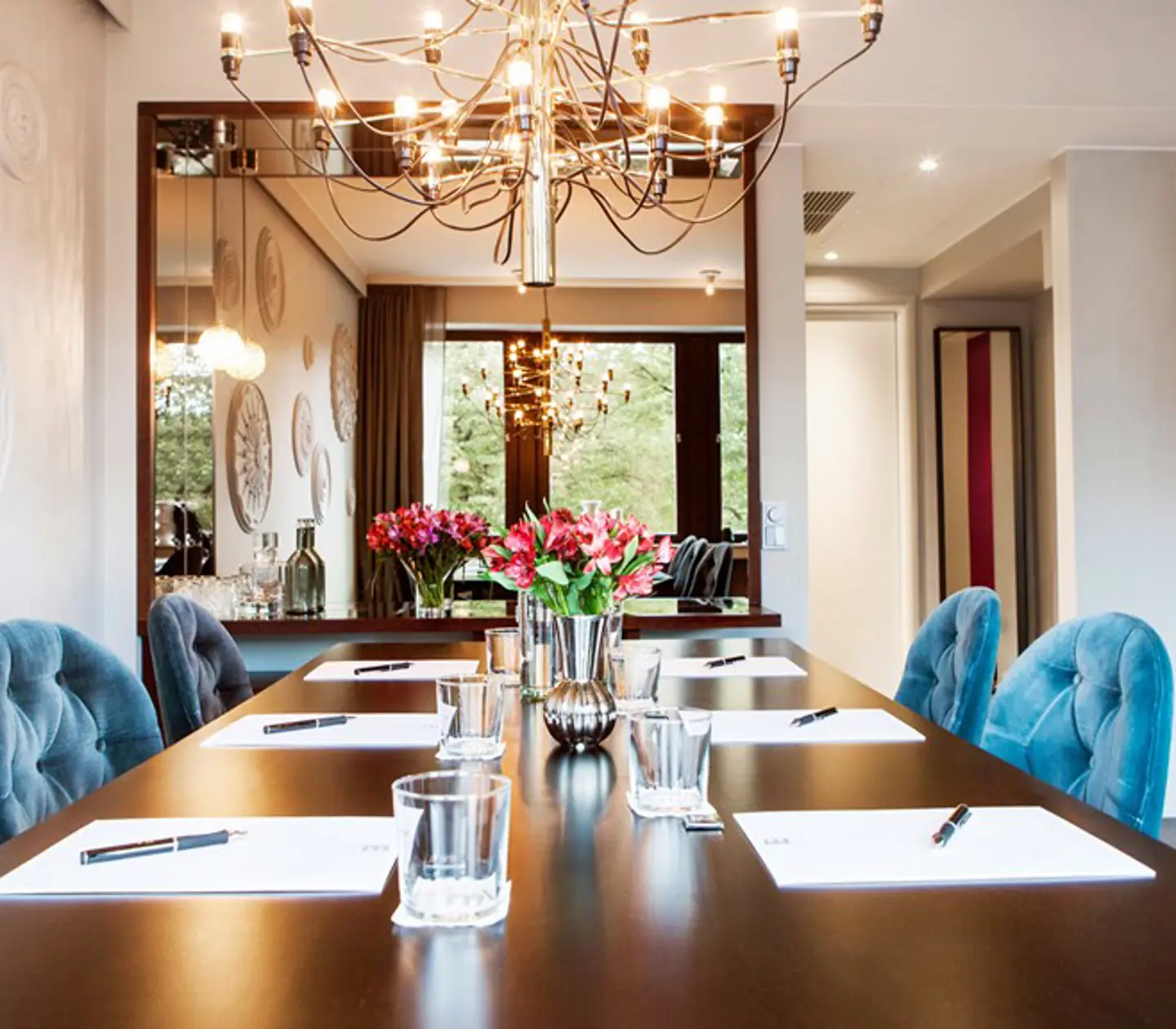 Board room with dark brown table, blue chairs and white walls