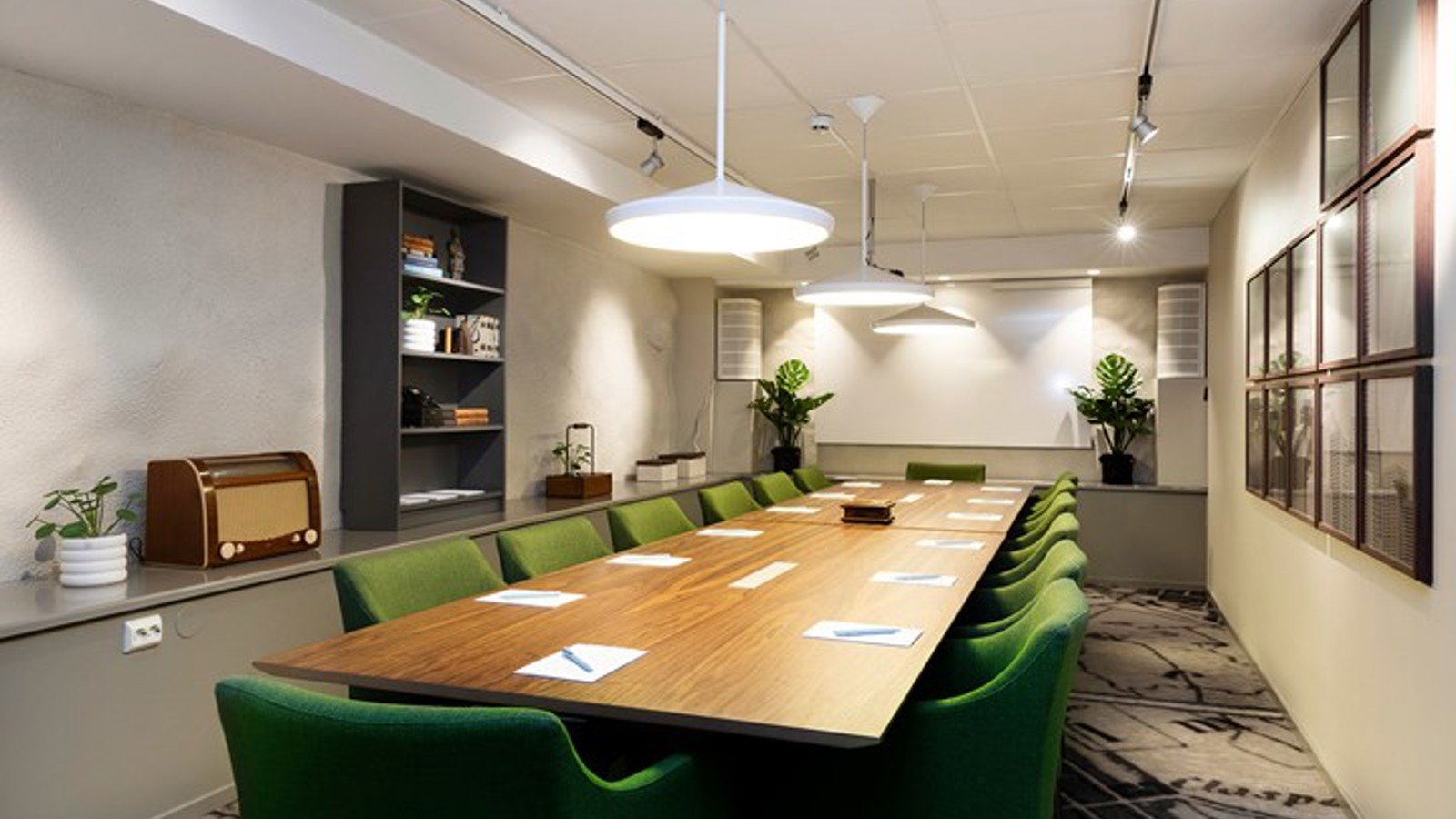 Conference room with board seating, dark brown table and green chairs