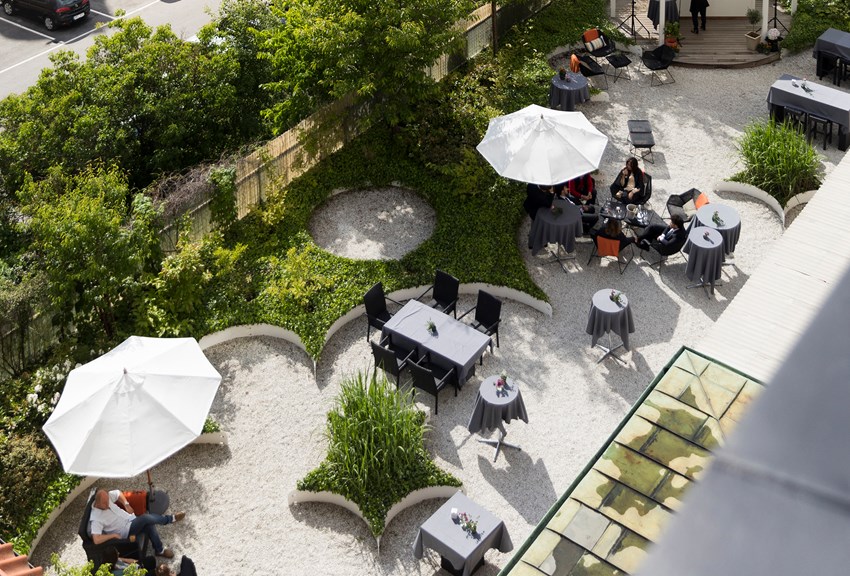 Trädgård med uteservering och parasoller