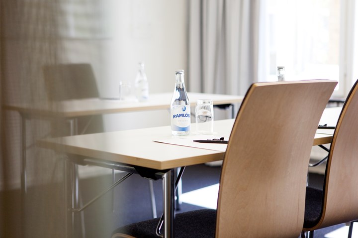 Conference room with tables set with pads, pens and water bottles