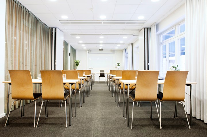 Conference room with school seating, wooden chairs, white walls and large windows