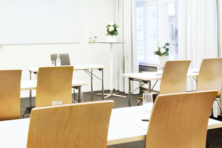 Conference room with school seating, wooden chairs and white walls