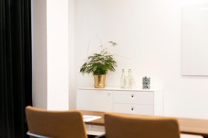 Conference environment with chair, white walls and drawers in the background