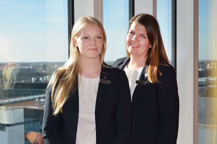 Picture of two people standing in front of a large window with a view
