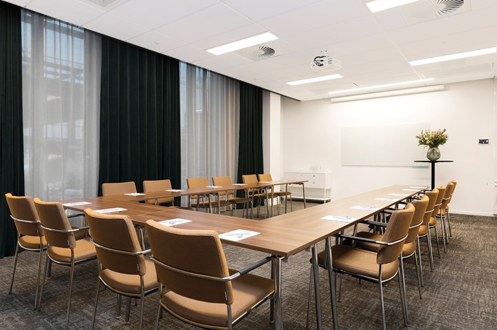 Conference room with u-shaped seating, brown furniture, white walls, gray carpet and large windows