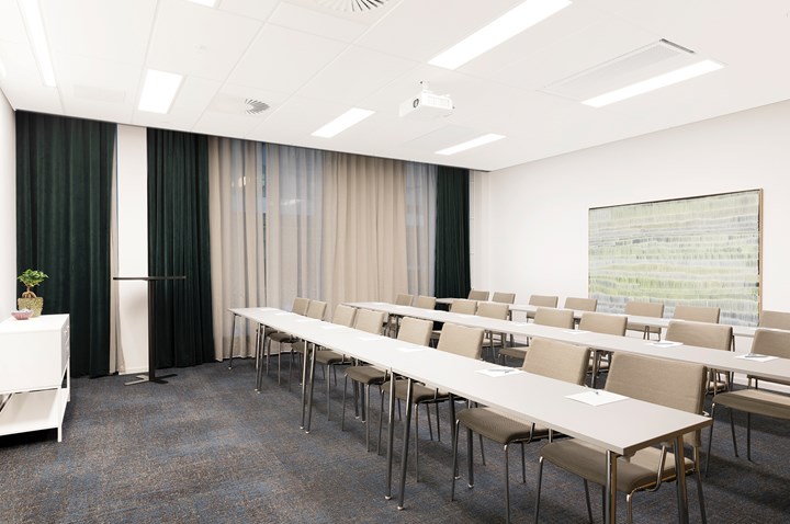 Conference room with school seating, white furniture, gray carpet and drawn curtains
