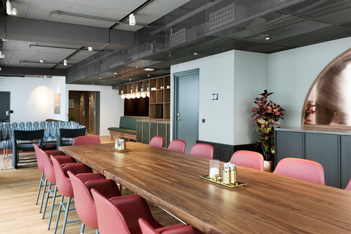 Conference room with board seating, brown table and red chairs