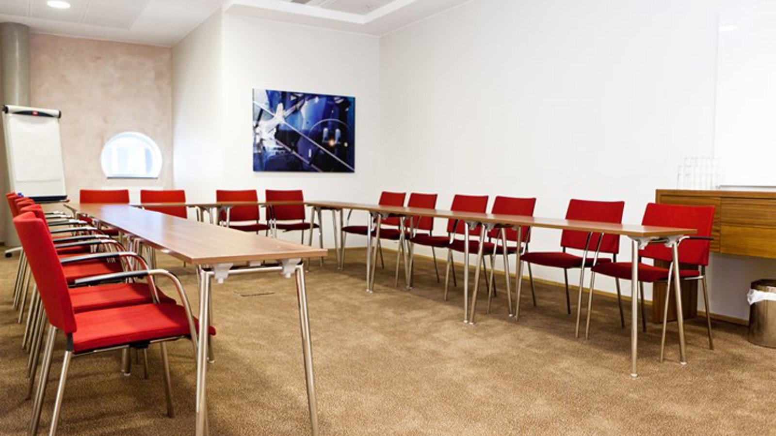 Conference room with cinema seating, red chairs, light gray floor and white walls