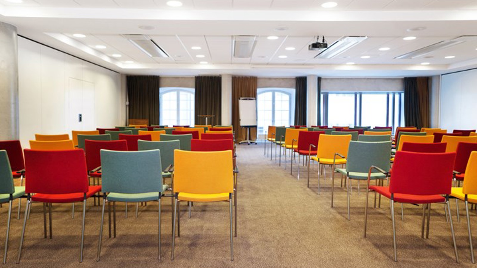 Conference room with colorful chairs, white walls and large windows
