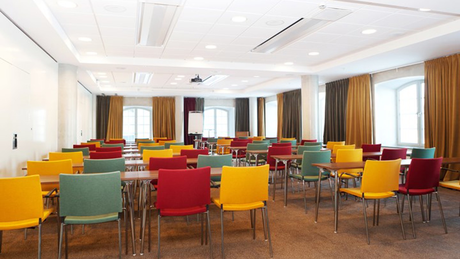 Conference room with lined up chairs, colorful chairs and large windows