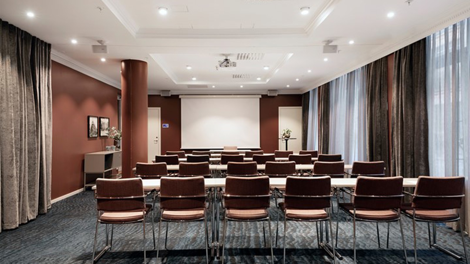 Conference room with lined up chairs, gray floor and brown walls