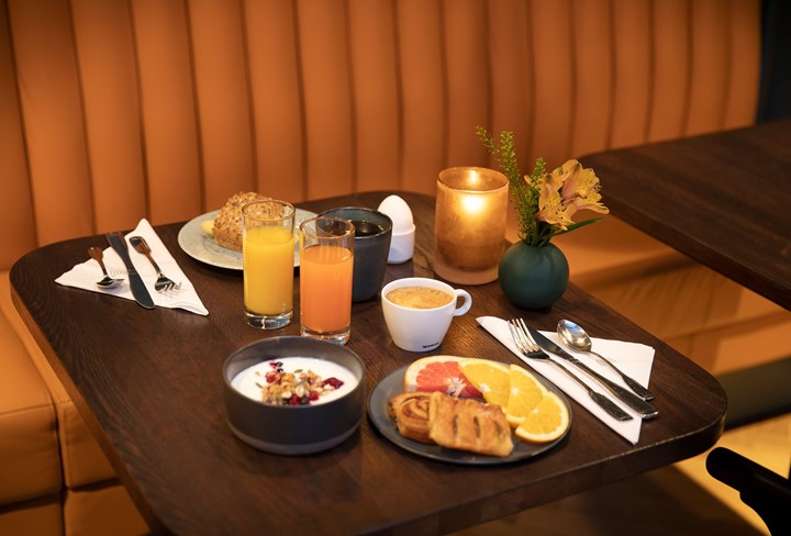 Uppdukad frukost för två med yoghurt, juice, kaffe