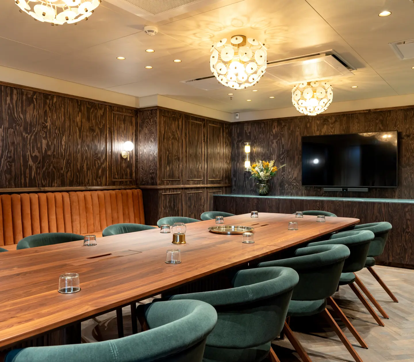 Conference room with dark walls and blue chairs.