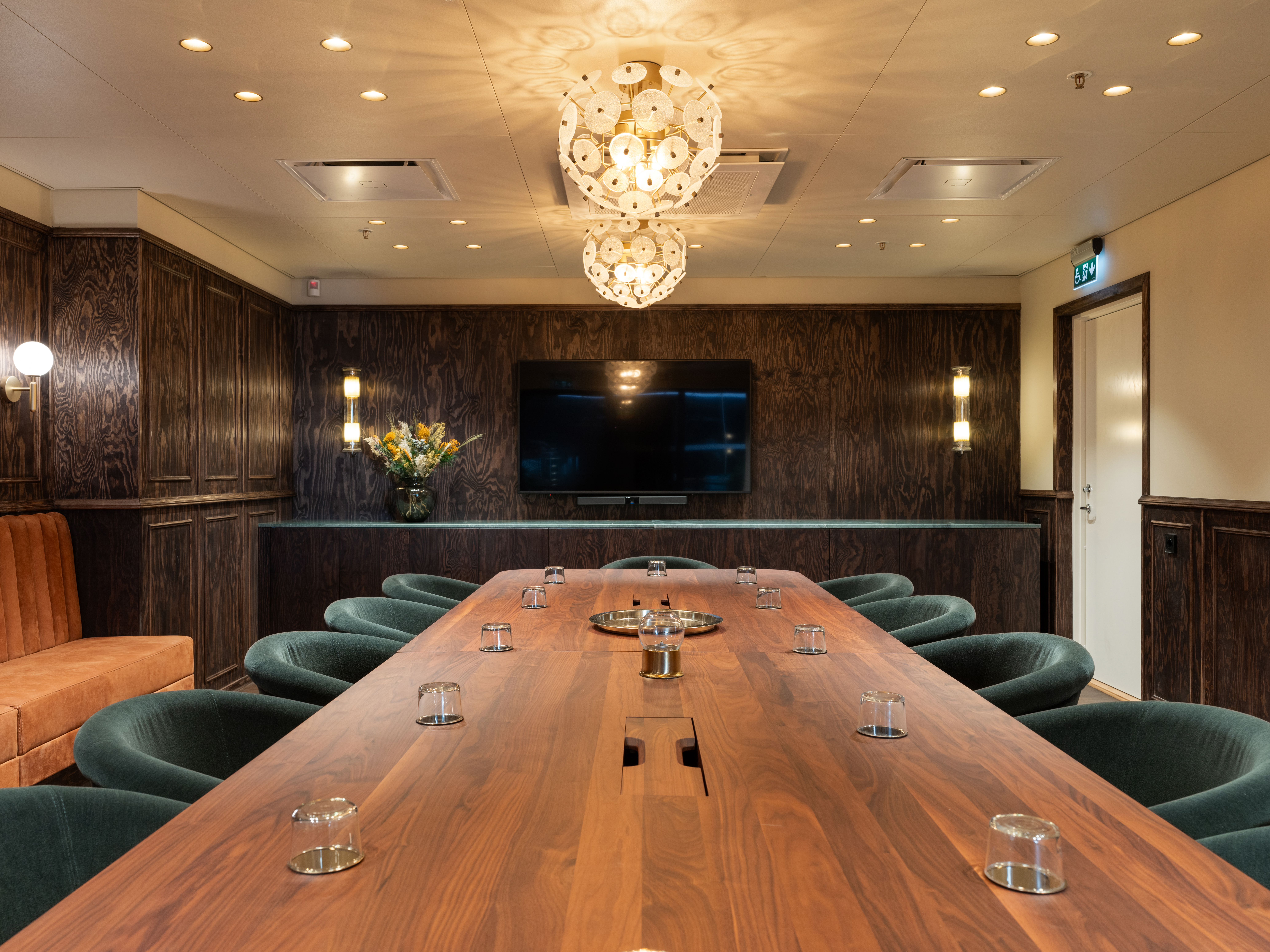 Konferensrum med mörka väggar och blåa stolar