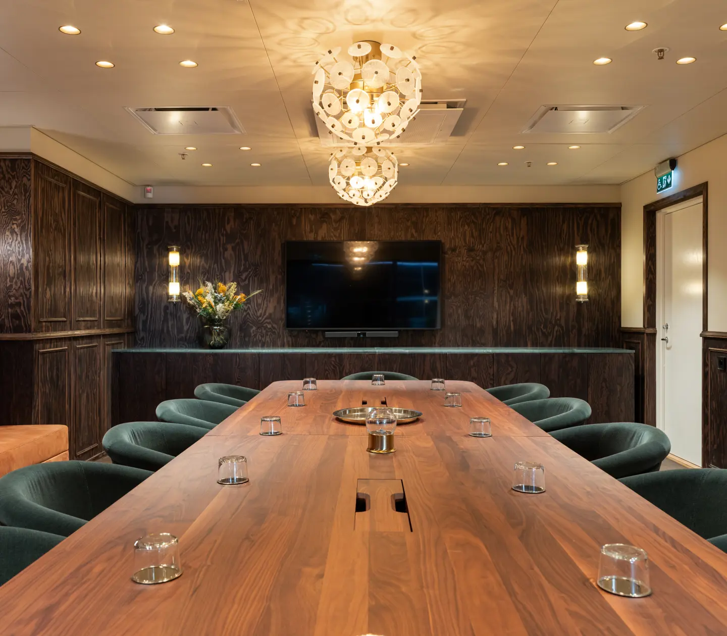 Conference room with dark walls and blue chairs.