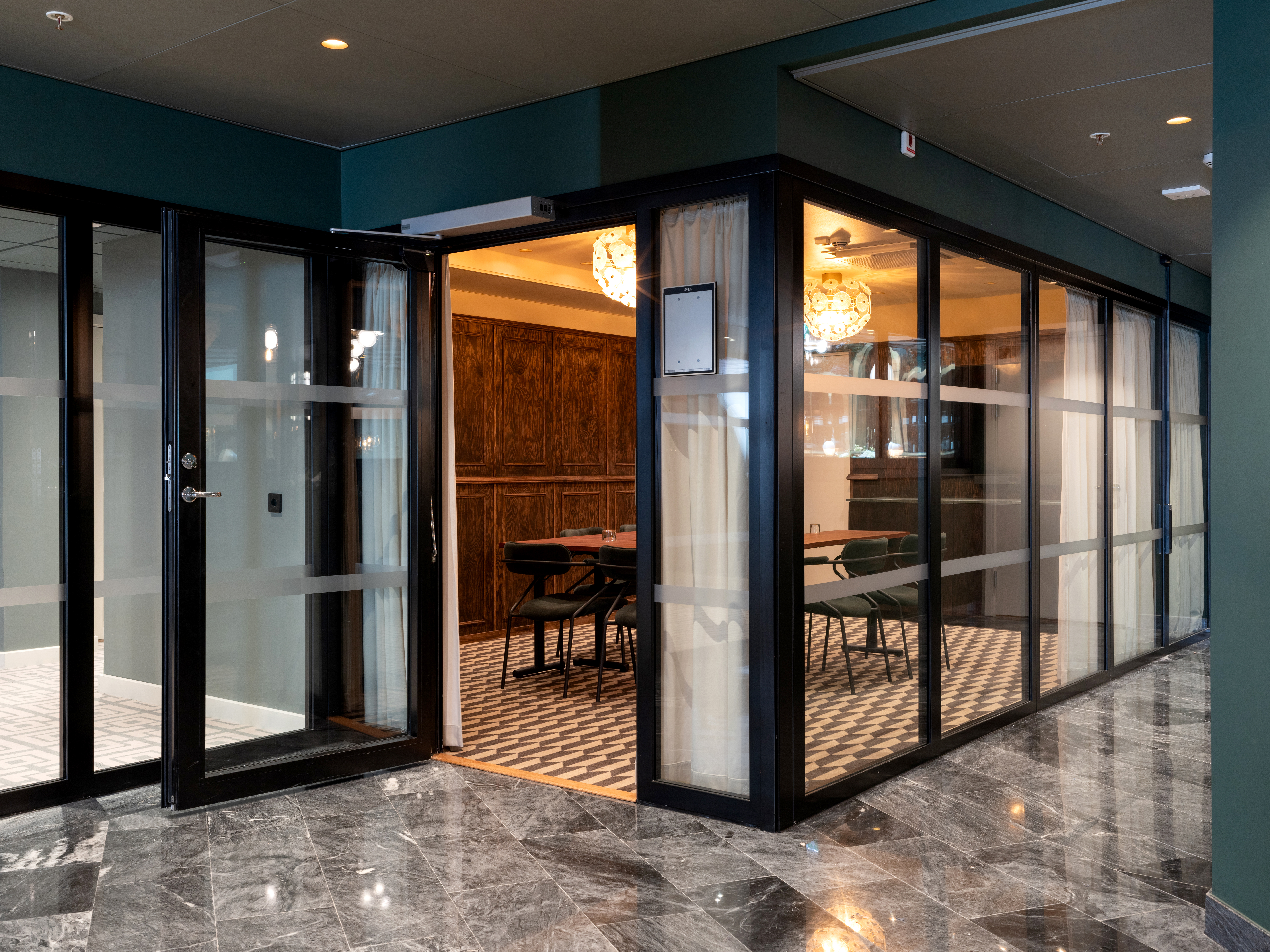 Modernt kontorsmötesrum med glasdörrar och lyxig inredning.