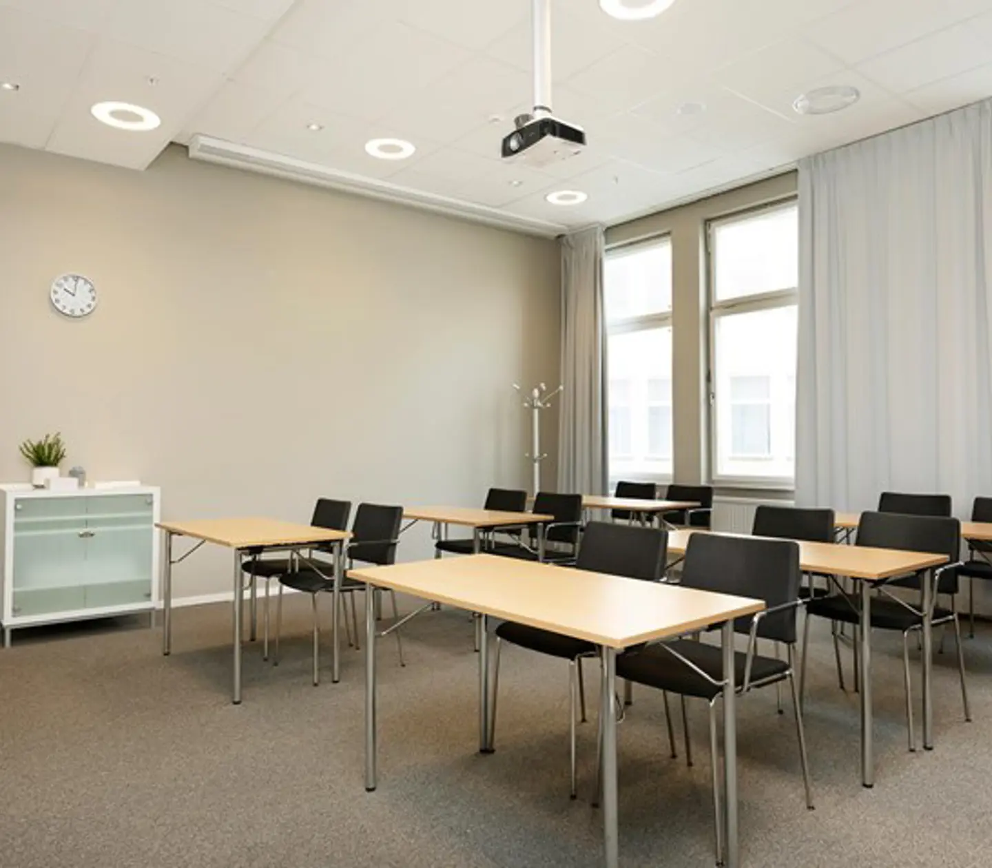 Conference room with school seating, large windows, brown carpet, wooden table