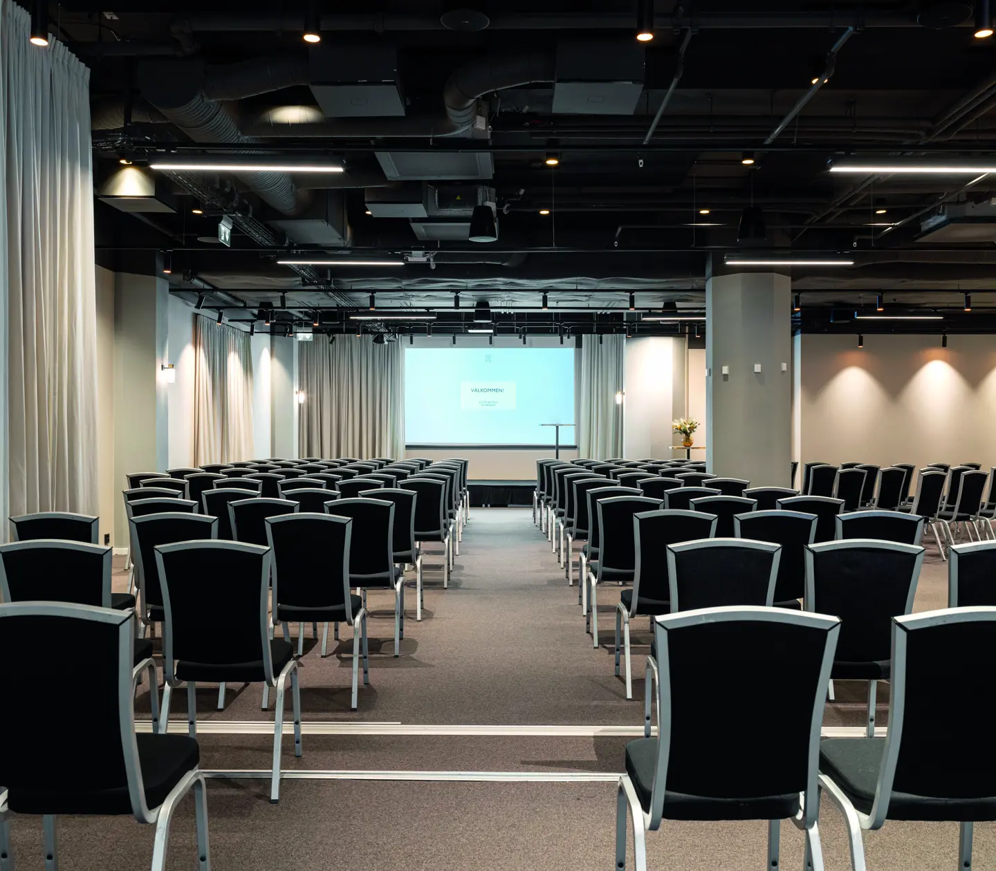 Conference room with u-shaped seating, dark chairs and white walls