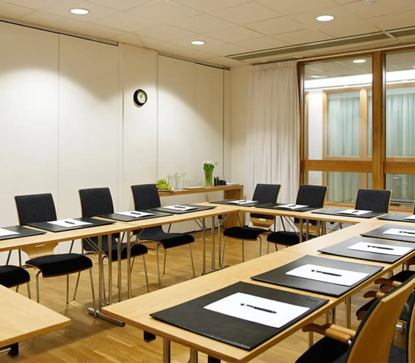Bright conference room with white walls and U-shaped seating