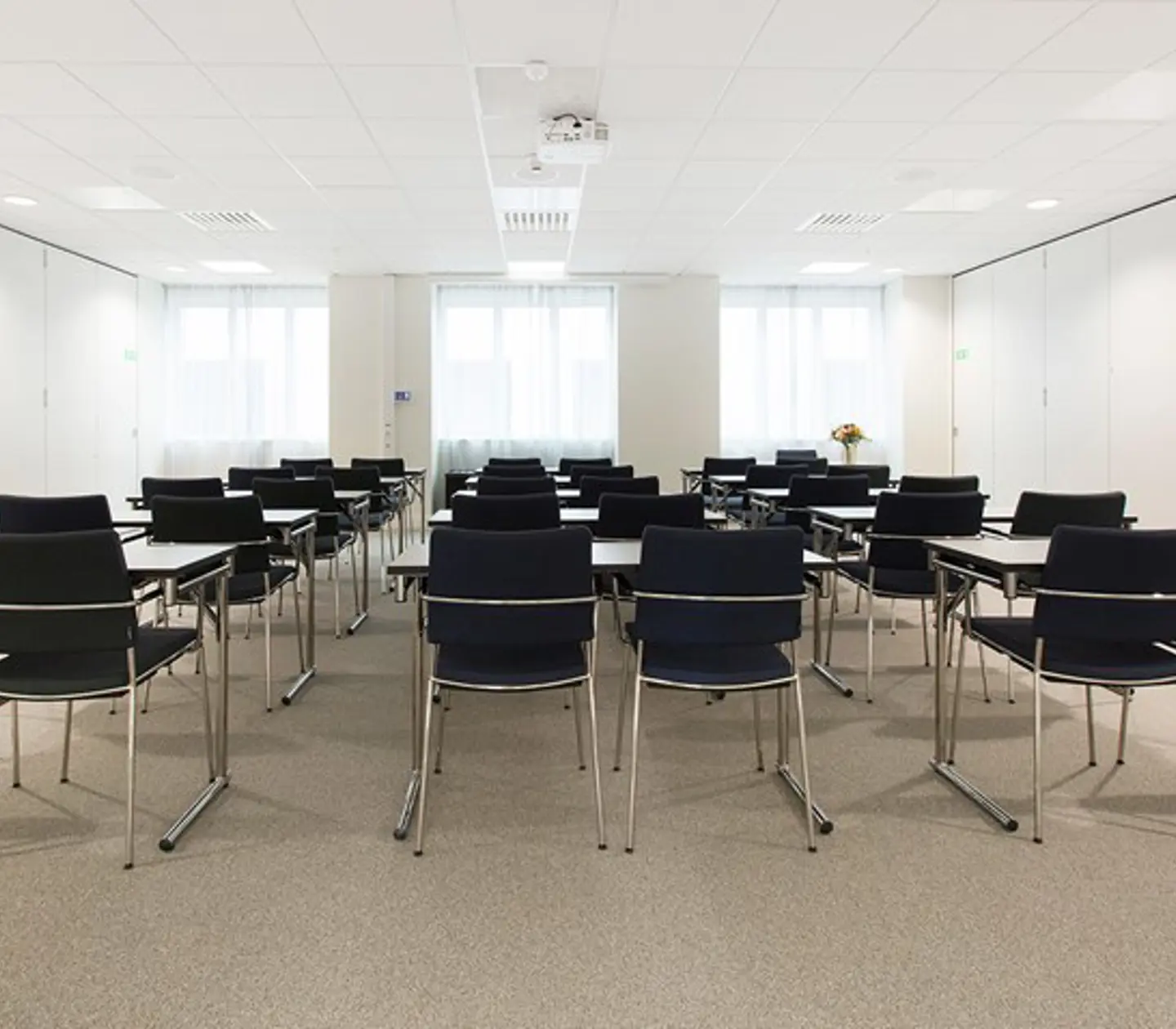 Conference room with school seating, white walls and black chairs