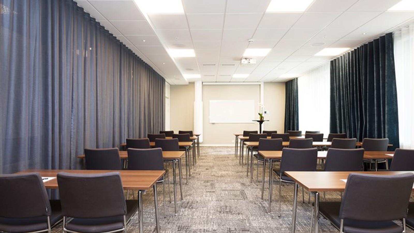 Conference room with school seating, gray floor and gray draperies
